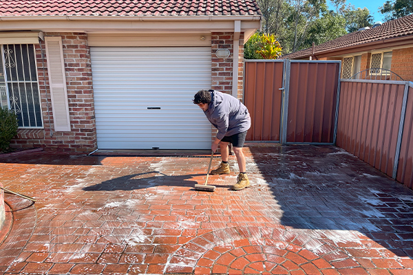 Driveway scrubbing during pressure cleaning service in Sydney